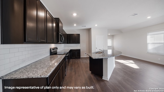 kitchen with a wealth of natural light, a center island with sink, dark hardwood / wood-style floors, and appliances with stainless steel finishes