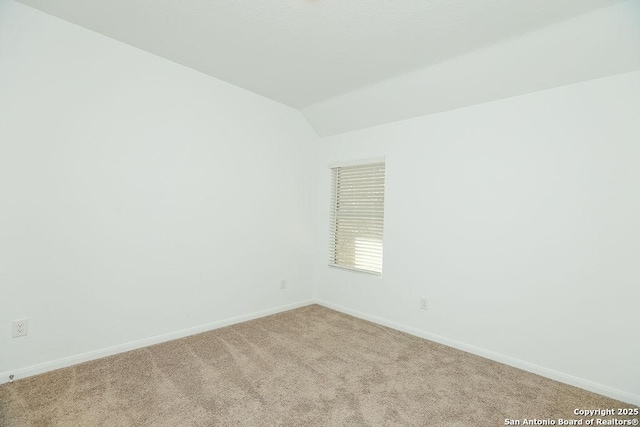 unfurnished room featuring light carpet and lofted ceiling