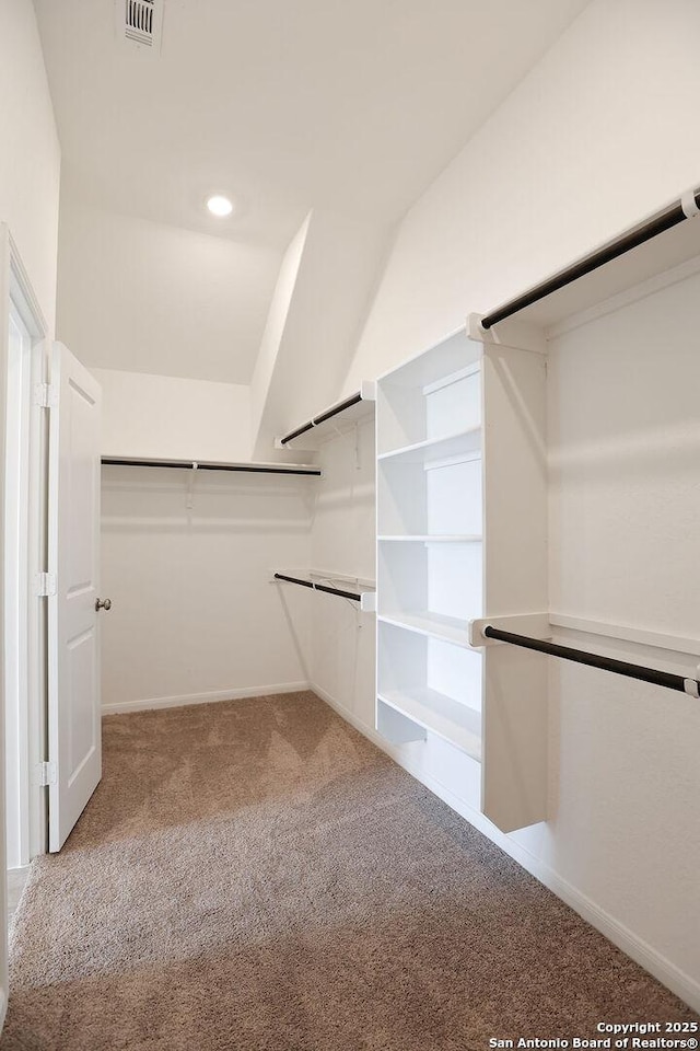 walk in closet featuring lofted ceiling and carpet floors