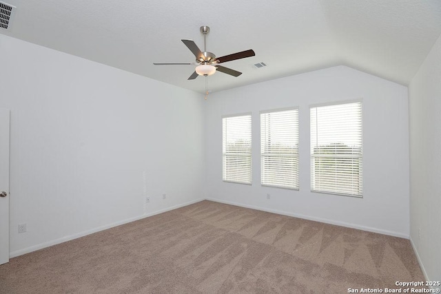 empty room featuring ceiling fan, light colored carpet, and lofted ceiling