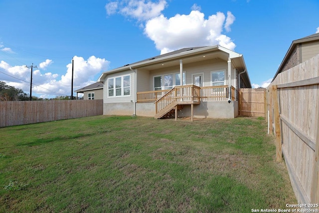 back of house featuring a lawn and a deck