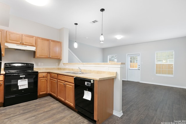 kitchen with dark wood-type flooring, sink, black appliances, and decorative light fixtures