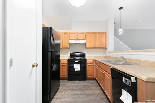 kitchen with hanging light fixtures, dark wood-type flooring, sink, and black appliances