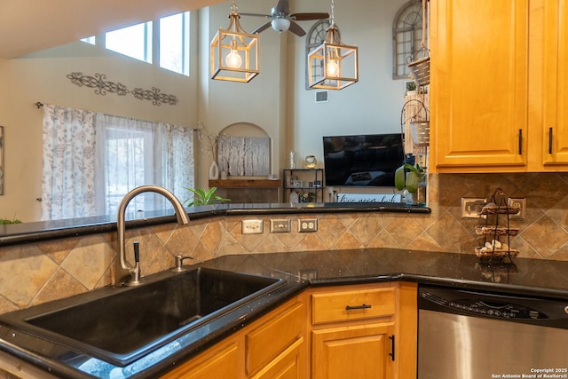 kitchen with stainless steel dishwasher, backsplash, pendant lighting, and sink