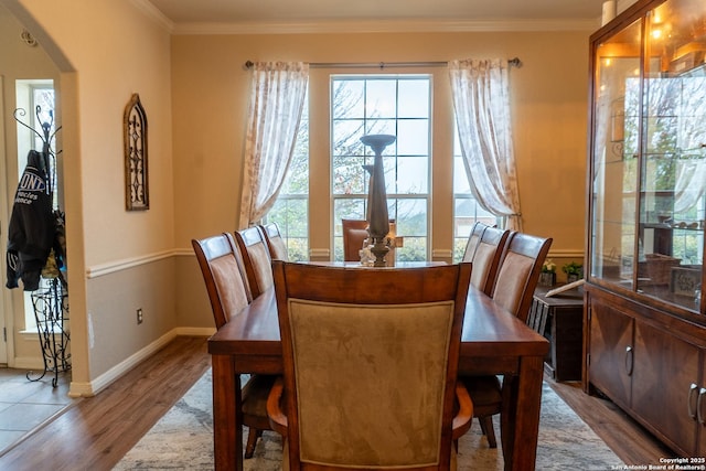 dining area featuring light wood-type flooring and crown molding