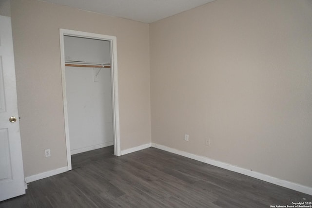 unfurnished bedroom with a closet and dark wood-type flooring