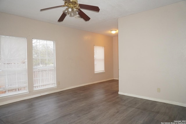 empty room with ceiling fan and dark hardwood / wood-style flooring