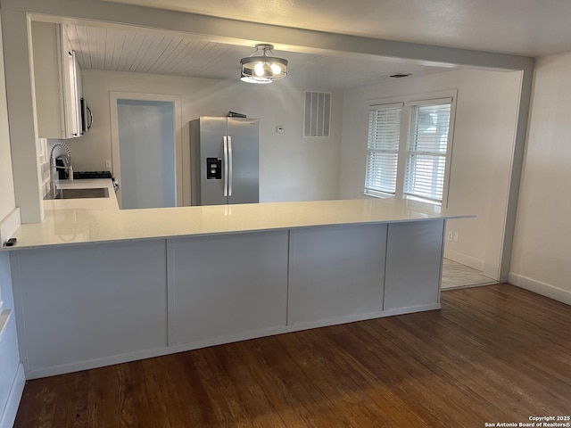 kitchen with kitchen peninsula, appliances with stainless steel finishes, dark hardwood / wood-style flooring, and sink