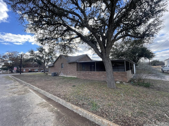 view of home's exterior featuring a sunroom and cooling unit