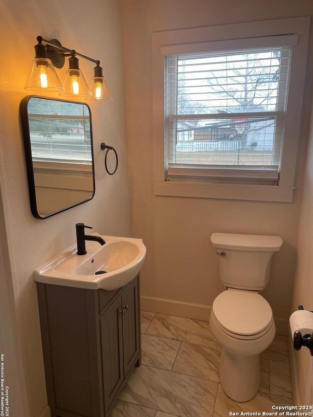 bathroom featuring plenty of natural light, vanity, and toilet