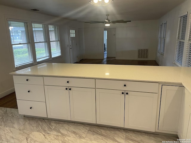 kitchen with white cabinetry and ceiling fan