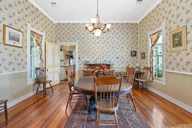 dining area featuring an inviting chandelier, dark hardwood / wood-style floors, and ornamental molding