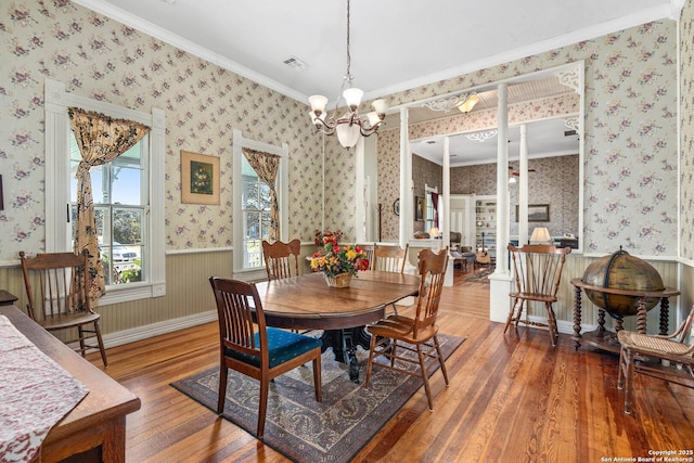 dining space featuring dark hardwood / wood-style floors, crown molding, and a chandelier