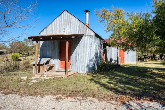 back of house featuring an outbuilding and a yard