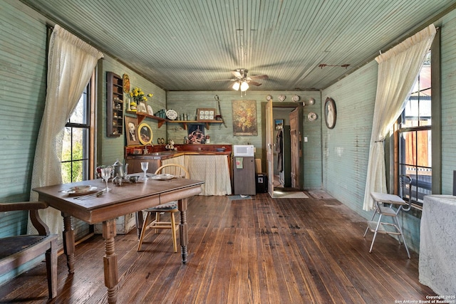 dining room featuring ceiling fan, wood-type flooring, and brick wall