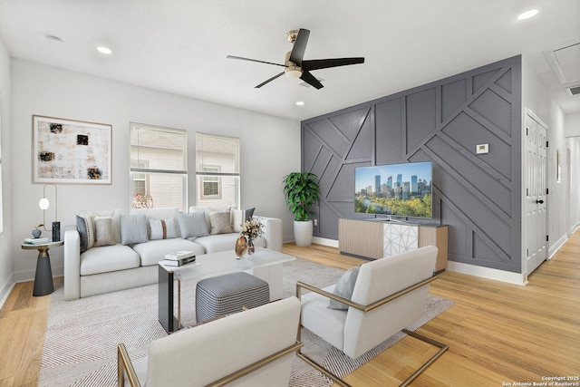 living room with light hardwood / wood-style flooring and ceiling fan