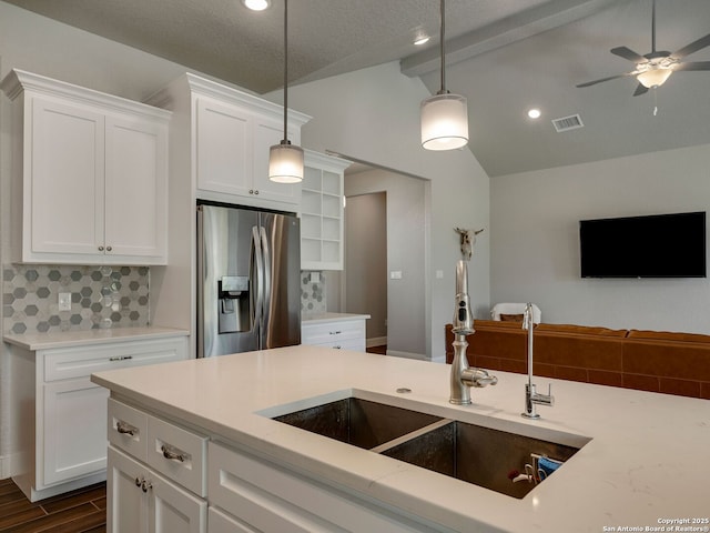 kitchen featuring white cabinetry, sink, hanging light fixtures, stainless steel refrigerator with ice dispenser, and decorative backsplash