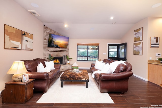 living room with vaulted ceiling and a brick fireplace