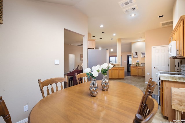 dining area with ceiling fan and vaulted ceiling