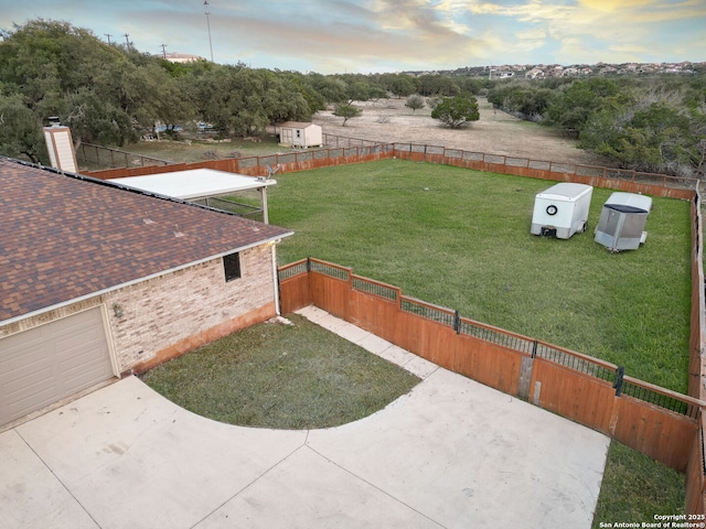 yard at dusk featuring a garage