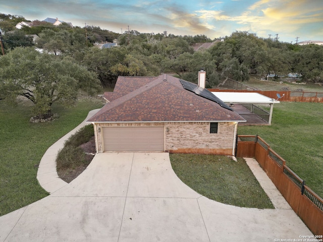 view of front of house featuring a yard, a garage, and solar panels