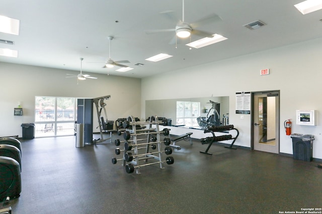 workout area with ceiling fan, a healthy amount of sunlight, and a high ceiling