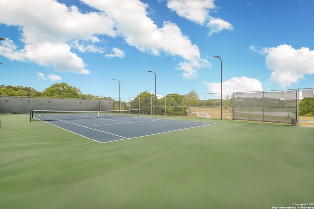 view of tennis court with basketball hoop