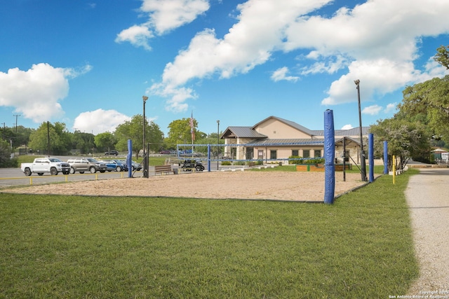 surrounding community with volleyball court and a lawn