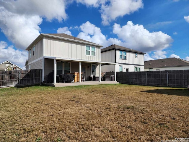 back of property featuring a lawn and a patio