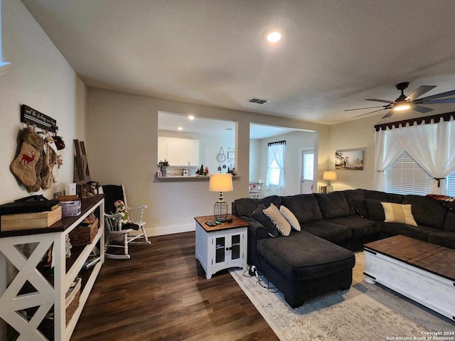 living room featuring ceiling fan and dark hardwood / wood-style floors