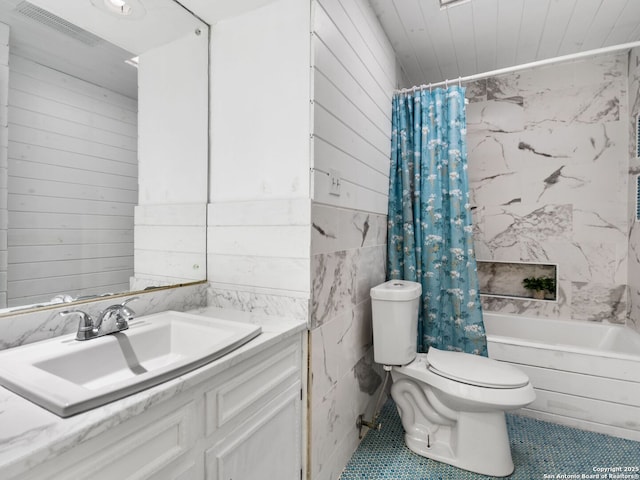 full bathroom featuring tile patterned floors, vanity, toilet, and shower / bath combo with shower curtain