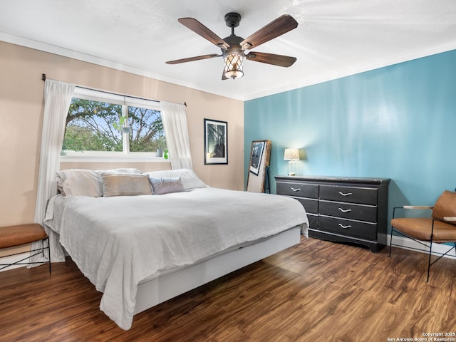 bedroom featuring dark hardwood / wood-style floors, ceiling fan, and crown molding