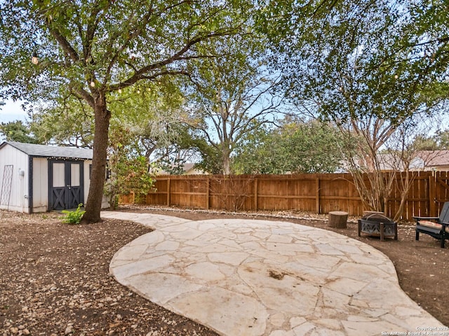 view of patio / terrace featuring a shed and a fire pit