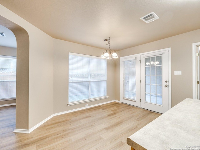 dining space with a notable chandelier, light hardwood / wood-style floors, and plenty of natural light