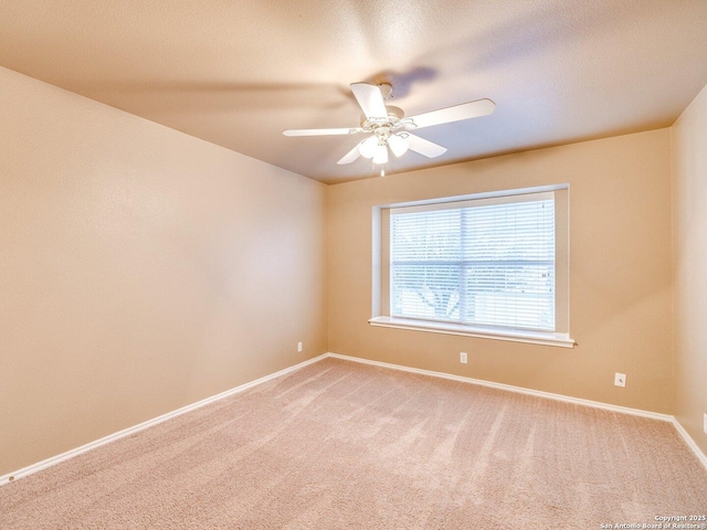 carpeted spare room featuring ceiling fan