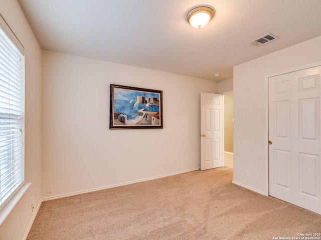 unfurnished bedroom featuring light carpet