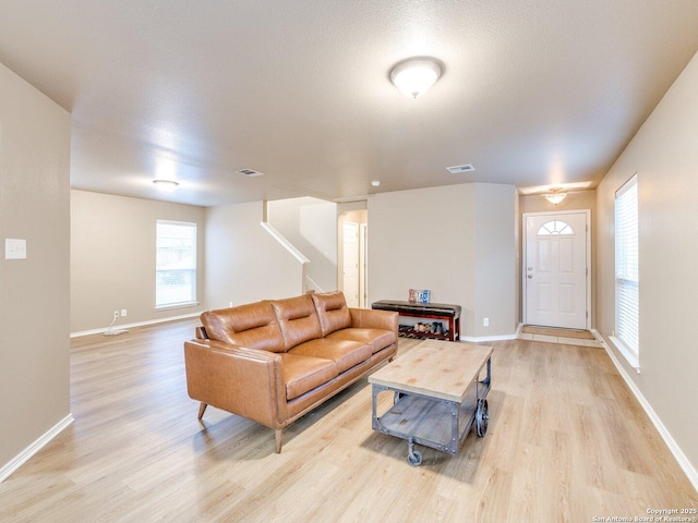 living room with a textured ceiling and light hardwood / wood-style flooring