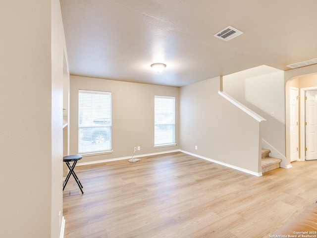 spare room featuring light hardwood / wood-style flooring and a textured ceiling