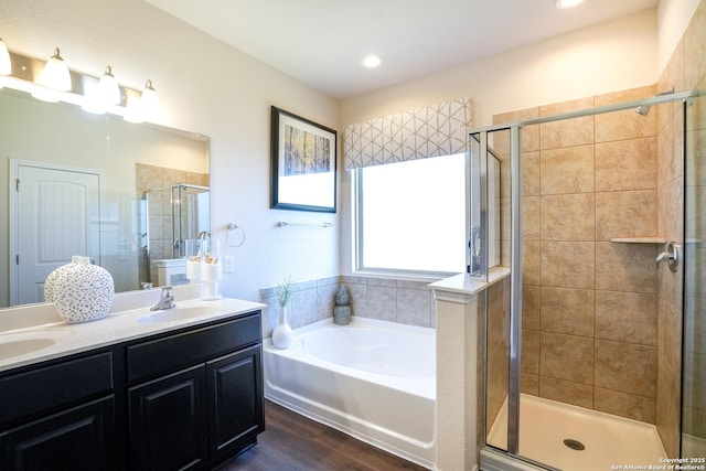 bathroom featuring hardwood / wood-style floors, vanity, and shower with separate bathtub