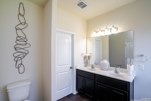 bathroom with hardwood / wood-style flooring, vanity, and toilet