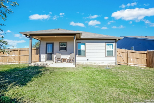 rear view of house featuring a yard and a patio