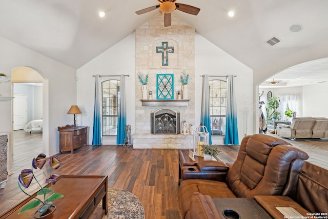 living room featuring a fireplace, dark hardwood / wood-style flooring, ceiling fan, and lofted ceiling