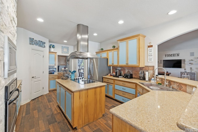 kitchen featuring sink, appliances with stainless steel finishes, a kitchen island, kitchen peninsula, and island exhaust hood