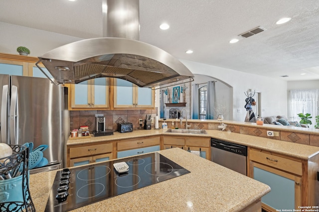 kitchen with kitchen peninsula, a textured ceiling, stainless steel appliances, island range hood, and sink