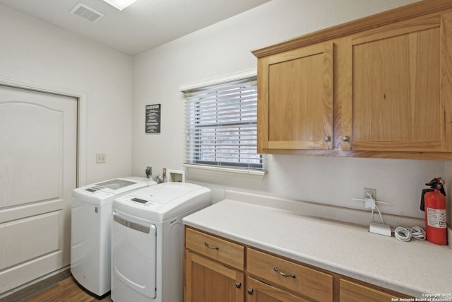 laundry area with cabinets, dark hardwood / wood-style flooring, and washer and dryer