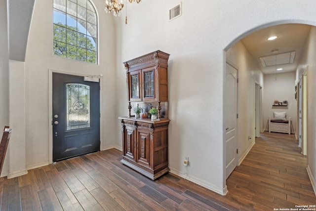 foyer with a towering ceiling and dark wood-type flooring