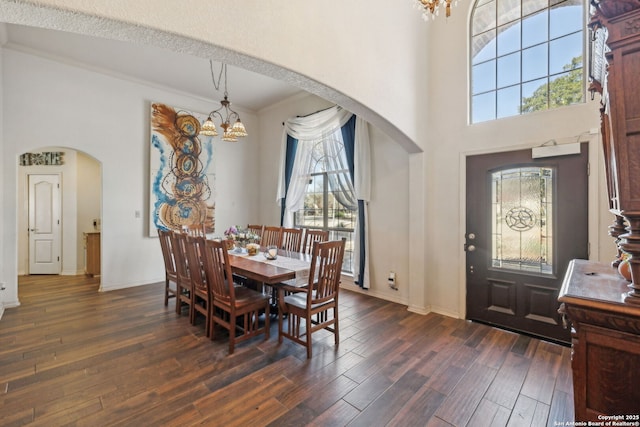 dining space with dark hardwood / wood-style floors and an inviting chandelier