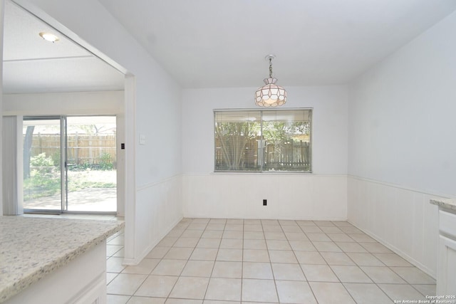 unfurnished dining area with light tile patterned floors and a healthy amount of sunlight