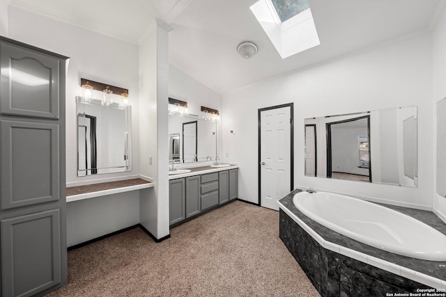 bathroom with vanity, tiled bath, lofted ceiling with skylight, and ornamental molding