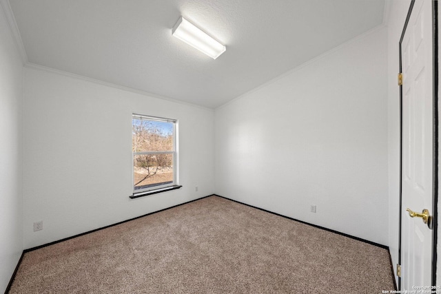 empty room featuring carpet flooring, ornamental molding, and vaulted ceiling